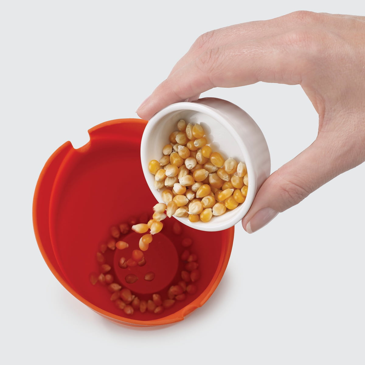 https://cdn.connox.com/m/100035/214373/media/joseph-joseph/M-Cuisine/M-Cuisine-Popcorn/Joseph-Joseph-M-Cuisine-Popcorn-Maker-orange-Mais-einfuellen.jpg