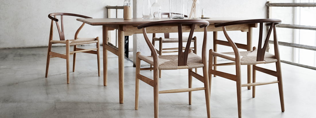 Lifestyle product image of the CH24 Wishbone Chair by Carl Hansen: The simple appearance makes it hard to guess that 100 individual steps are needed to make the chair.