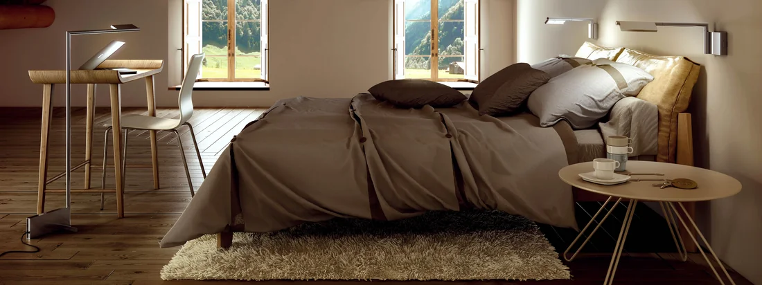 The lamp consists of a base with a swivel arm on which an adjustable lampshade is attached. The reading light is well above the bed.