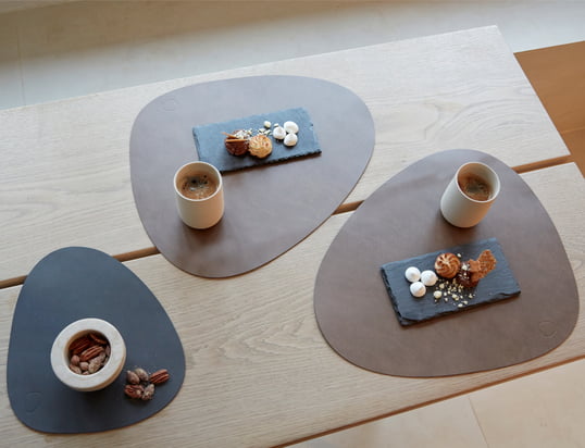 The Curve placemat by LindDNA in the ambience view: The placemat is made of recycled leather and optimally protects the dining table from scratches and stains.