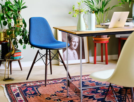 The Eames Plastic Side Chair DSW by Vitra in the ambience view: The filigree chair becomes an absolute eye-catcher in the living room thanks to the bright blue.