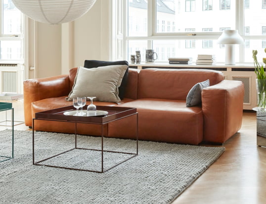 The Mags soft sofa by Hay in the ambience view: The high-quality leather sofa in cognac can be perfectly combined with beige cushions and a grey carpet.