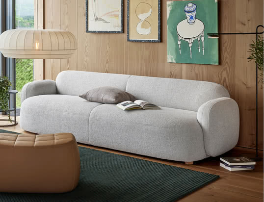 The Mags soft sofa by Hay in the ambience view: The high-quality leather sofa in cognac can be perfectly combined with beige cushions and a grey carpet.