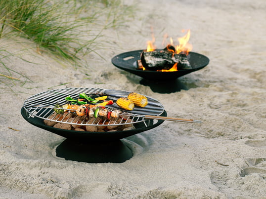 The Helios fire pit from Skagerak creates a cozy atmosphere and mood in the garden. It is also perfect for barbecuing with the accompanying stainless steel grill.