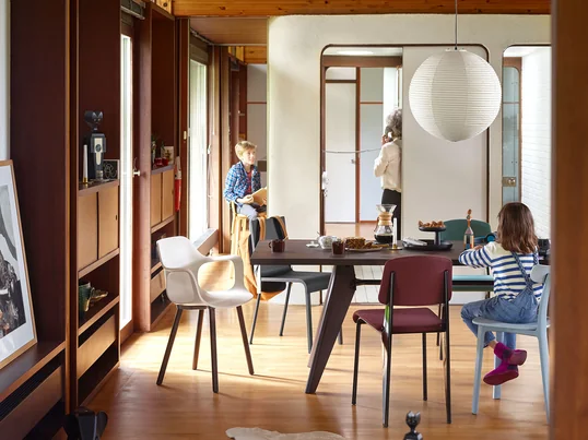 The modern dining area has been equipped with Vitra furniture. The spacious Solvay dining table offers enough space for many chairs, for example the All Plastic Chair.