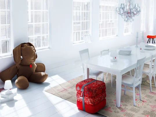 The furniture from Dutch manufacturer Fatboy fits perfectly into the minimalist interior of the bright dining room. The red fabrics provide a striking eye-catcher.