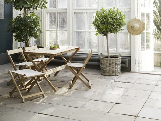 The outdoor furniture is particularly suitable for the winter garden. The garden furniture in untreated teak is designed by Børge Mogensen.