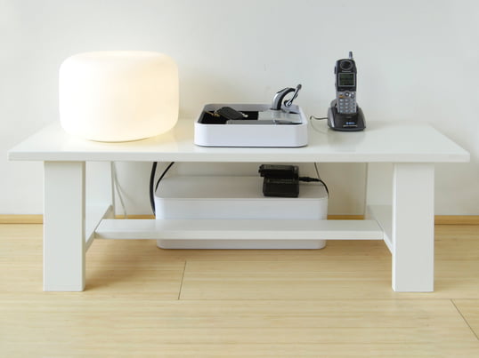 The CableBox by Bluelounge in the ambience view: The storage box makes the unwanted tangle of cables disappear quickly and easily under the coffee table.