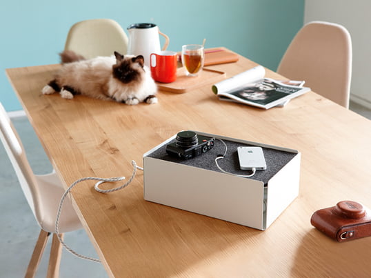 The charge box by Konstantin Slawinski in the ambience view: The box hides charging cables of iPhones, cameras and other devices stylishly on the kitchen table.