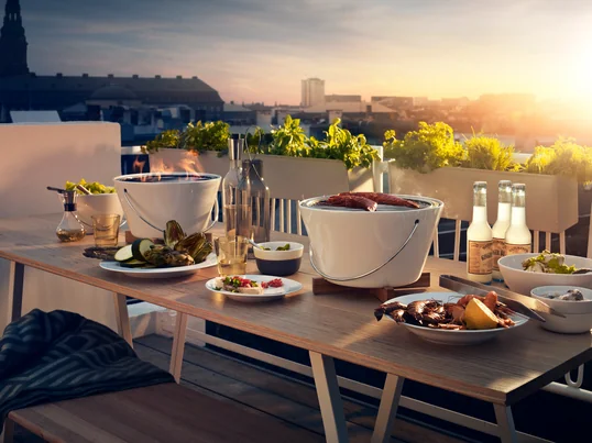 The table grill from Eva Solo in the ambience view: The simple table grill with its handle and wooden coaster ensures delicious barbecue evenings in summer.
