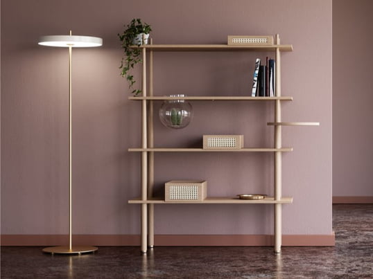 Asteria LED floor lamp from Umage in the ambience view. The floor lamp is equipped with an LED panel and gives off a glare-free, downward light through the diffuser, which can also be dimmed if necessary. The look is rounded off by the Stories floor shelf with 4 shelves and accessories.