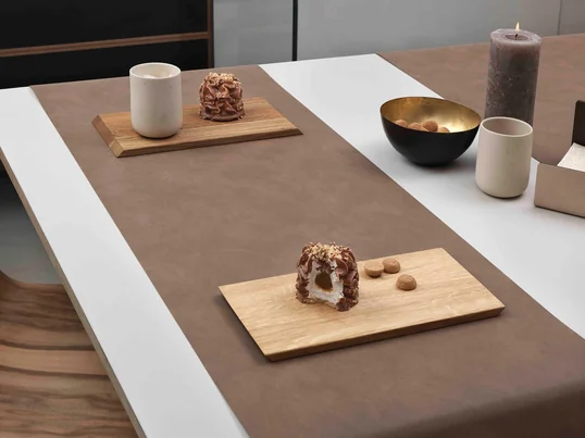 The Table Runner by Lind DNA in Nupo brown adapts itself perfectly to the table thanks to the soft leather