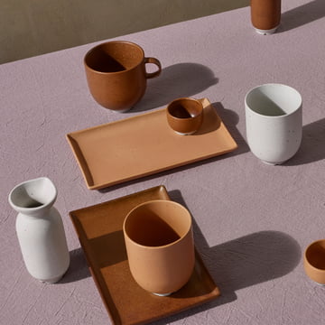 The Eli tableware by Broste Copenhagen in caramel and soft light grey matt on a lilac tablecloth