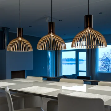 The Victo Small 4251 pendant lamp from Secto above a long, white dining table