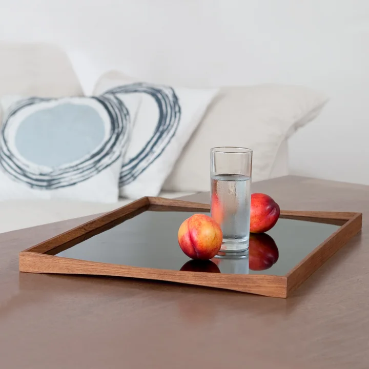 The Tablett Turning Tray with a glass next to the sofa