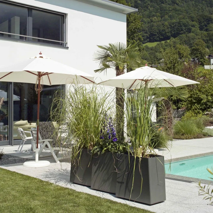 The Twista plant pots from Eternit next to the pool in the garden