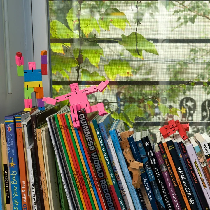 The Cubebot from Areaware climbs on piles of books
