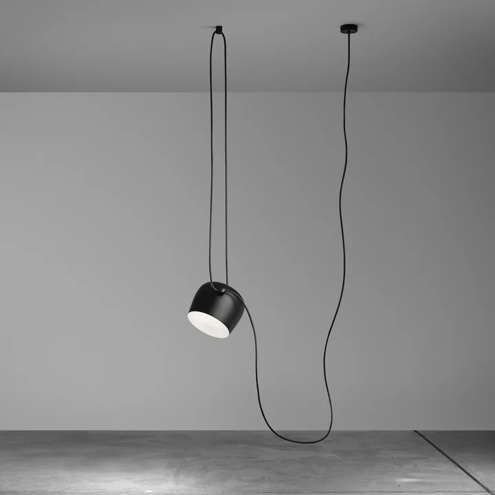 The AIM pendant light, black from Flos in an empty room