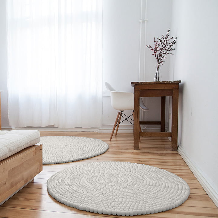 Linéa Round rug from myfelt in front of the bed