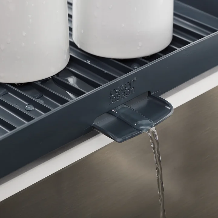 Dish rack with inclined ribs and drain plug