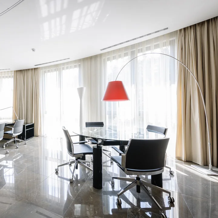 The Lady Costanza floor lamp by Luceplan above an oval table in an office