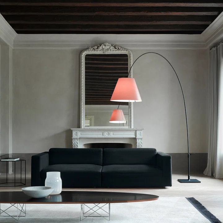 The Lady Costanza floor lamp by Luceplan above a couch in a stylish living room