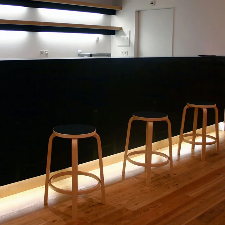The Artek - 64 Bar Stool in Birch / Black at the Bar