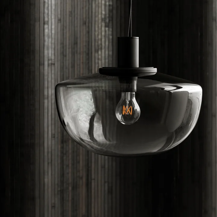 Bench pendant lamp from Audo in front of a dark concrete wall