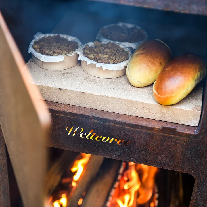 Outdoor steel oven from Weltevree with rolls on the pizza stone 