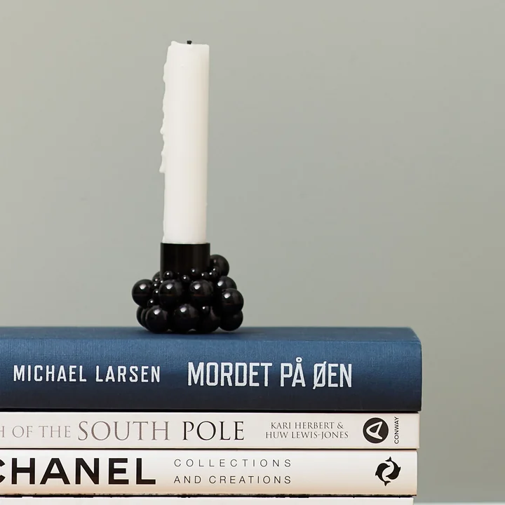 Molekyl candle holder 1 black by Gejst placed on books