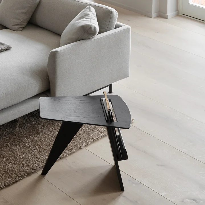 Risom magazine side table in oak black varnished by Fredericia next to the sofa