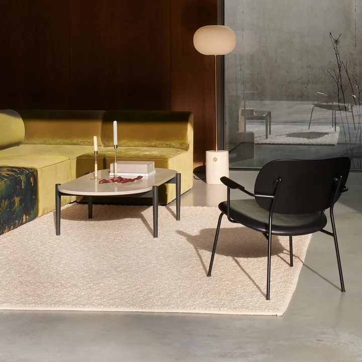 Gravel rug in ivory, Co lounge chair in black and JWDA floor lamp in travertine / bronzed brass by Audo