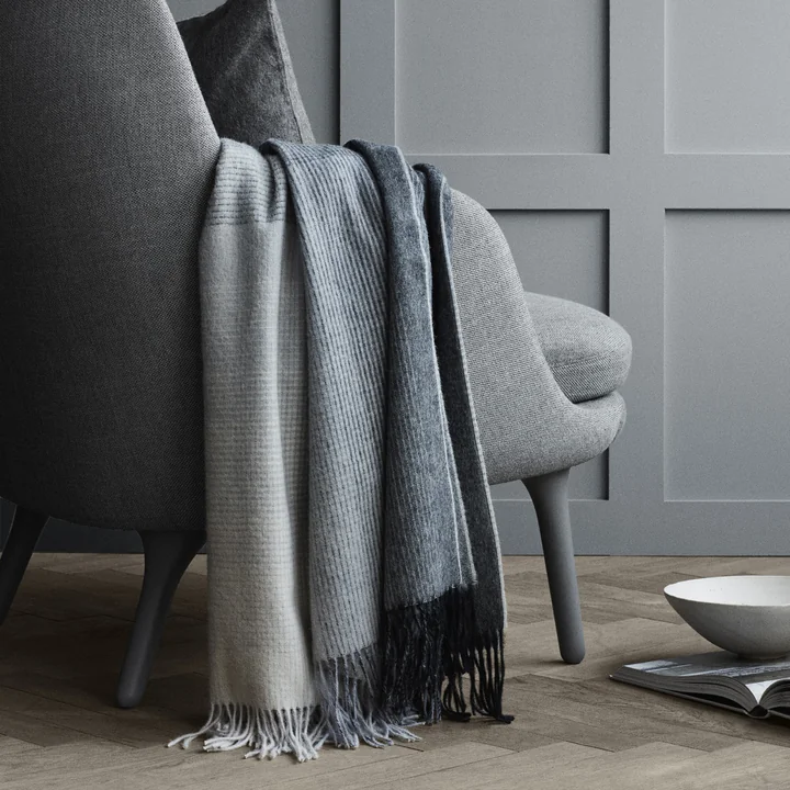 Horizon Blanket, gray from Elvang over the armchair