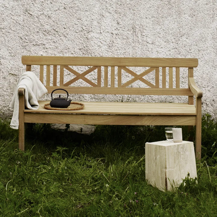 The Drachmann Bench from Skagerak in front of a wall on the lawn