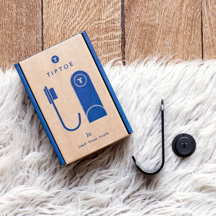 The JO wall hook, graphite black from TipToe next to its material- TipToe packaging