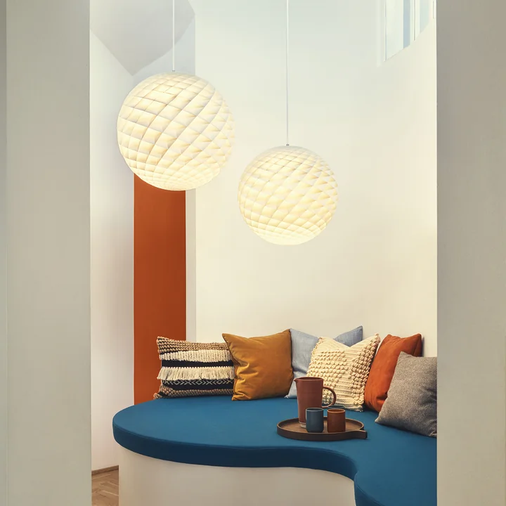 The Patera Pendant lamp from Louis Poulsen above a cozy sitting area