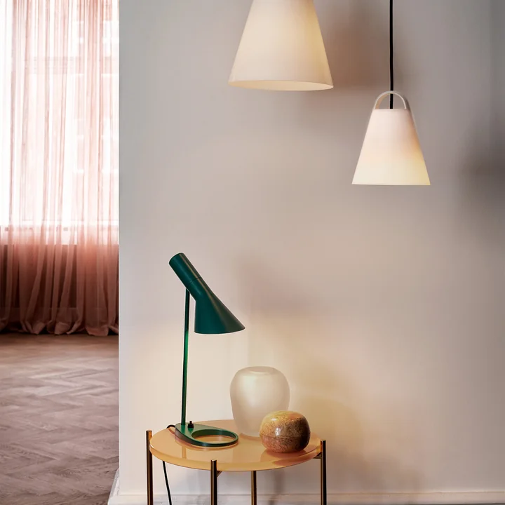The AJ table lamp from Louis Poulsen on a wooden side table in the hallway