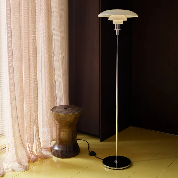 The PH floor lamp, high-gloss chrome-plated from Louis Poulsen in the darkened bedroom