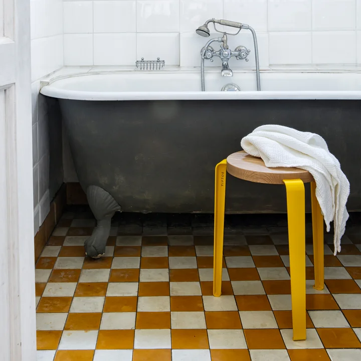 The LOU stool oak natural, sunflower yellow as a shelf in the bathroom