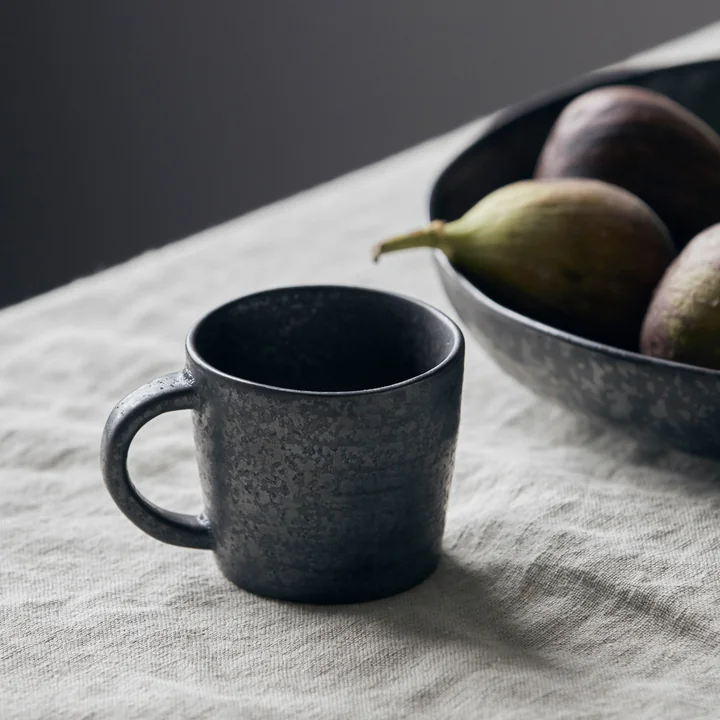 The mug with handle Pion in front of a fruit plate