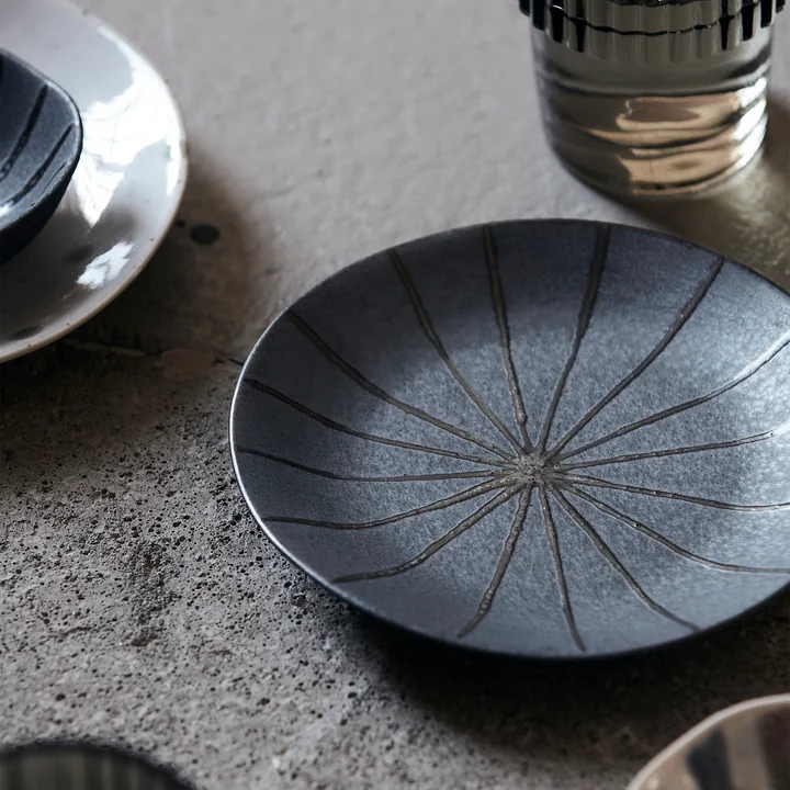 The Suns plate, Ø 15.7 cm, dark brown by House Doctor with other dishes on the dining table