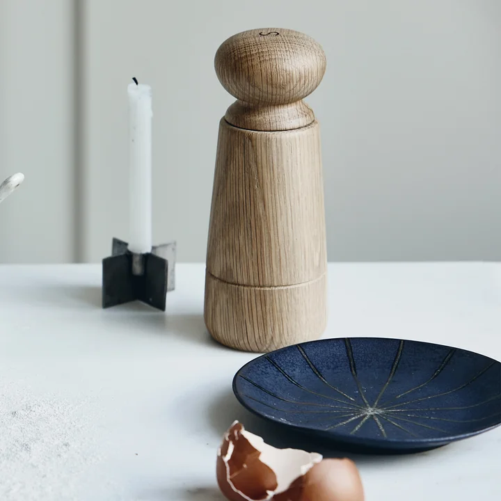 The Wardha salt and pepper mill and the Suns plate by House Doctor on a light table in the kitchen