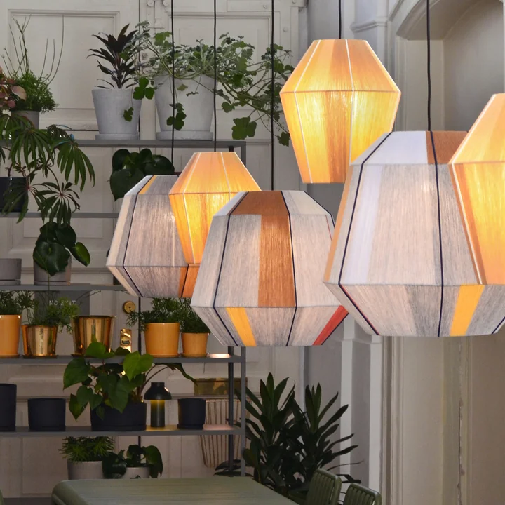 The candy lampshades by HAY in a glowing state in a room with lots of plants