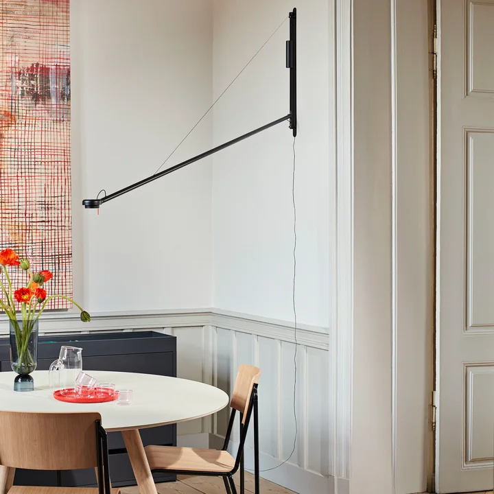 The Fifty-Fifty wall lamp, soft black by HAY above the dining table in the bright dining room