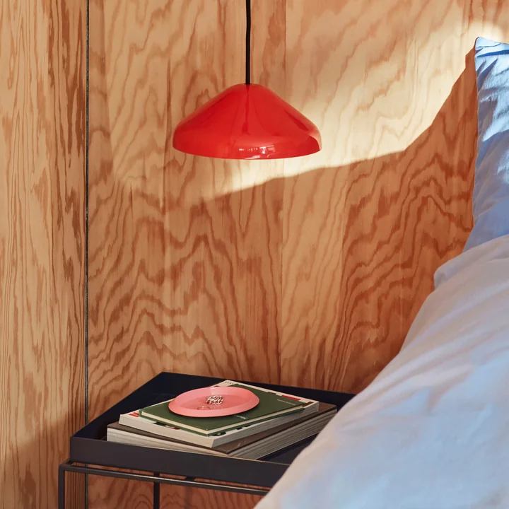 The Pao Steel pendant lamp, Ø 23 x H 10 cm, red by HAY above the bedside table next to the bed