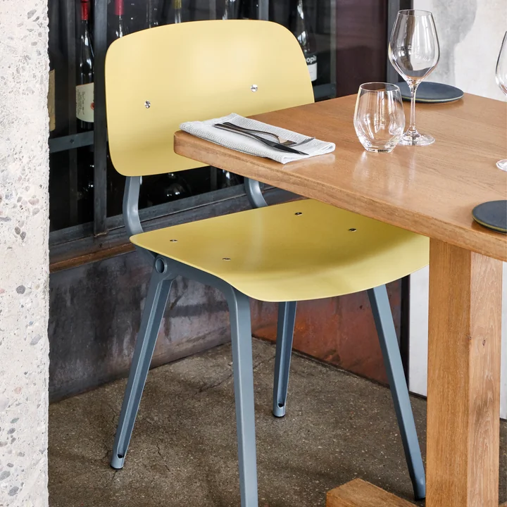 The Revolt Chair, ocean / biscotti by HAY on a laid wooden table