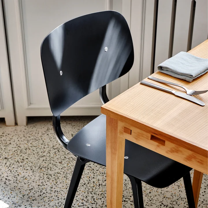 The Revolt Chair, black / black by HAY on a wooden dining table