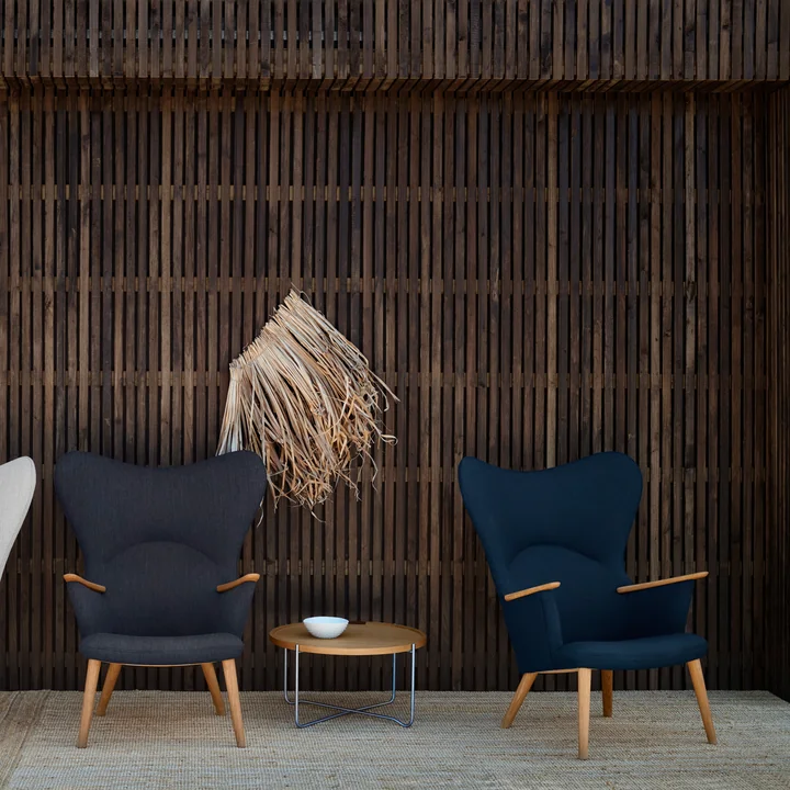 The CH78 Mama Bear Lounge Chair from Carl Hansen next to a small side table