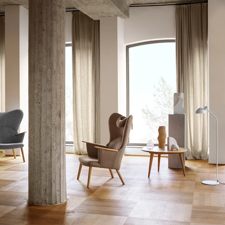 The CH78 Mama Bear Lounge Chair of Carl Hansen in a bright room with stone columns and wooden floor