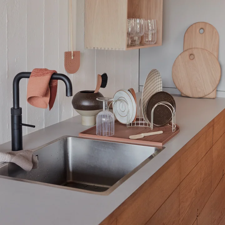 The draining rack, the draining mat and the yumi cutting boards from OYOY next to the sink in the kitchen